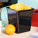 A black container with oranges in it.