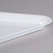 A white plastic triangular tray with a curved edge.