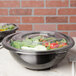 Two Fineline clear flat lids on salad bowls filled with salad.