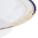 A close up of a Fineline white bowl with a blue and gold rim.