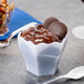A white plastic Fineline Tiny Hexagon bowl filled with chocolate pudding.