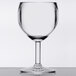 A clear GET SAN plastic wine glass on a white surface.