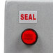A close up of a red button with black text that says "seal"