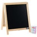 A black chalkboard with a wooden frame on a table with a small box of chalk.