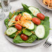 A 10 Strawberry Street gray stoneware plate with a salad of spinach, tomatoes, cucumbers, and carrots.