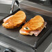 Two grilled sandwiches cooking on a Galaxy Panini grill.