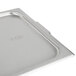 A Vollrath stainless steel steam table pan cover on a tray.
