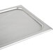 A Vollrath stainless steel pan cover on a stainless steel tray.