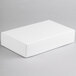 A 9 3/8" x 5 5/8" x 2" white rectangular candy box on a gray surface.