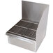 A stainless steel floor mounted mop sink drain with a grate.