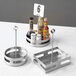 An American Metalcraft stainless steel rectangular condiment caddy with card holder holding condiments on a table.