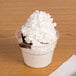 A WNA Comet classic dessert specialty cup of ice cream with whipped cream on top.