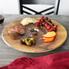 An American Metalcraft melamine serving board with cheese, meat, and grapes on a table.