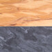 A close-up of an American Metalcraft olive wood serving board with black and gray marble accents.