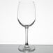 A close-up of a clear Reserve by Libbey wine glass on a reflective surface.