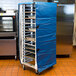 A blue Cres Cor bun pan rack cover on a large rack with trays.