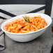 A Libbey Aluma White porcelain serving bowl filled with pasta and tomato sauce on a table.