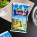 A Hidden Valley packet of fat free Italian dressing next to a bowl of Italian salad.