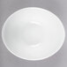 A Libbey aluma white porcelain infinity bowl with a curved edge.