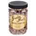 A jar of Grandma Jack's Gourmet Chocolate Caramel Popcorn on a table.