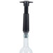 A Vacu Vin wine saver vacuum pump with a black handle and two glass stoppers.