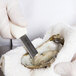 A person in gloves using a Dexter Russell Boston Style oyster knife to open an oyster.