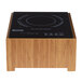 A black Cal-Mil induction cooker on a bamboo stand.