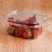 A Dart ClearPac plastic container filled with strawberries and covered with a dome lid.