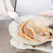 A person in white gloves using a Dexter-Russell scallop knife to cut an oyster shell.
