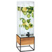 A Cal-Mil Madera beverage dispenser with lemon and limes in the water over ice.