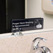 A Tablecraft Proper Hand Washing Is Recommended For All sign on a counter.