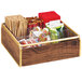 A Cal-Mil wooden condiment organizer with brass accents holding a variety of food items.