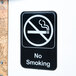 A black and white Thunder Group no smoking sign on a white wall.