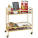 A brass Cal-Mil beverage cart with walnut shelves holding drinks and bottles.