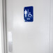 A blue and white handicap accessible men's restroom sign on a door.