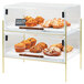 A Cal-Mil Mid-Century pastry case on a counter with muffins, pastries, and cookies inside.