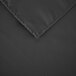 A close up of a black square polyester table cover with a hemmed edge.