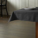 A table with a black Intedge 100% polyester tablecloth on it.