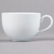 A close-up of a Tuxton white porcelain cappuccino cup with a handle.
