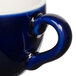 A close-up of a blue Tuxton cappuccino cup with a handle.