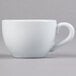 A close-up of a Tuxton porcelain white cappuccino cup with a handle.