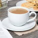 A Tuxton white cappuccino saucer with a cup of coffee and cookies.