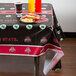 A table with an Ohio State University table cover and food and drinks on it.