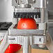 A tomato being diced by a Nemco Easy Chopper vegetable dicer.