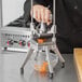 A person using a Nemco Easy Chopper to dice carrots.