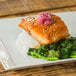 A 10 Strawberry Street Whittier Elite white porcelain square plate with salmon, broccoli, and rice on it.