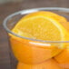 A bowl of oranges in a Fabri-Kal clear plastic deli container.