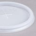 A white plastic Cambro lid with a straw slot and a cross on it.