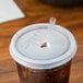 A plastic Cambro tumbler with a straw and lid on a table.