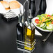A Tablecraft chrome rack holding a bottle of olive oil and a bottle of vinegar.